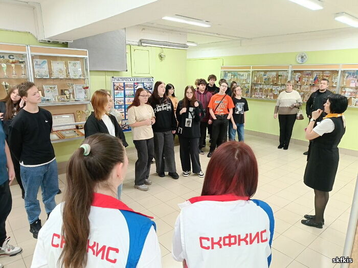 Нажмите для увеличения Ковдорские школьники и волонтеры в фойе колледжа. В стеклянных витринах кубки и грамоты за спортивные достижения команд колледжа